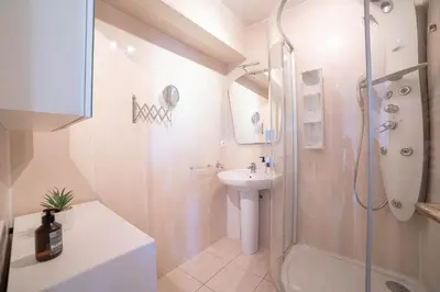 a white bathroom with a shower and a sink at Cannes Elegance – Balcony & Quiet Near Shops in Cannes