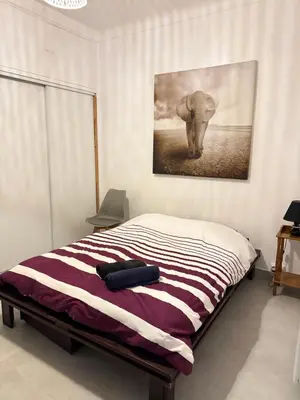 a bedroom with an elephant painting on the wall at Appartement WHITE DESIGN Proche Cannes in Le Cannet