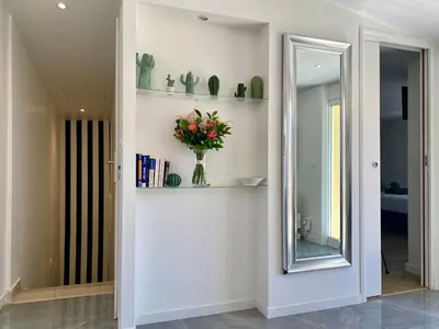 a hallway with a mirror and a vase of flowers at Duplex Luxury Toîts du Soleil By SCLS Locations in Cannes