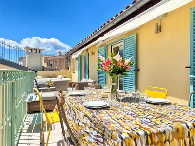 a table with a vase of flowers on a balcony at Duplex Luxury Toîts du Soleil By SCLS Locations in Cannes