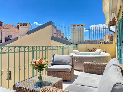 a patio with wicker chairs and a table on a balcony at Duplex Luxury Toîts du Soleil By SCLS Locations in Cannes