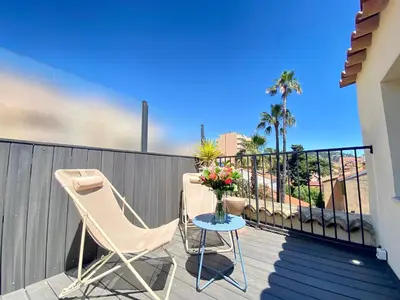 a balcony with two chairs and a table with flowers at Duplex Luxury Toîts du Soleil By SCLS Locations in Cannes