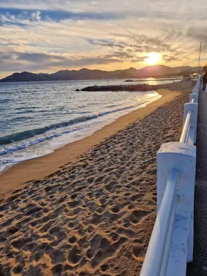 a view of the beach at sunset at VILLA MAUPASSANT BORD DE MER in Cannes