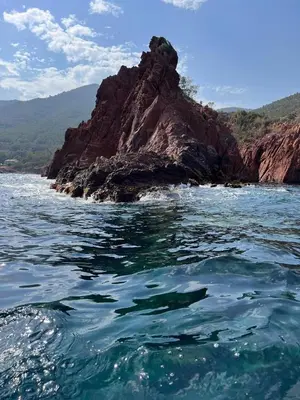 a large rock in the water with a mountain at VILLA MAUPASSANT BORD DE MER in Cannes