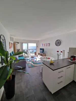 a kitchen and living room with a view of the ocean at VILLA MAUPASSANT BORD DE MER in Cannes