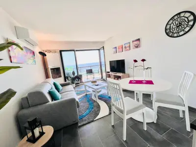a living room with a couch and a table at VILLA MAUPASSANT BORD DE MER in Cannes