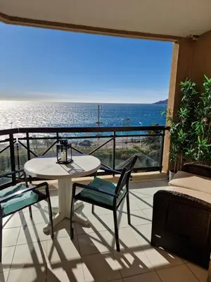 a balcony with a table and chairs and a view of the ocean at VILLA MAUPASSANT BORD DE MER in Cannes