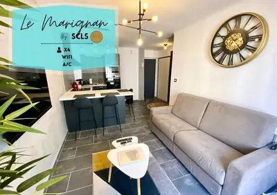a living room with a couch and a clock on the wall at Le Marignan By SCLS Locations in Cannes