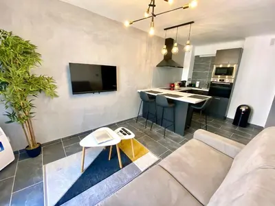 a living room with a couch and a kitchen at Le Marignan By SCLS Locations in Cannes