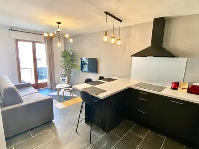 a kitchen with a counter and a living room at Le Marignan By SCLS Locations in Cannes