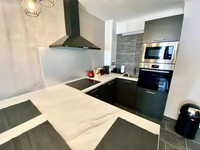 a kitchen with a counter top and a stove top oven at Le Marignan By SCLS Locations in Cannes