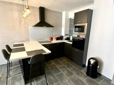 a kitchen with a table and a stove top oven at Le Marignan By SCLS Locations in Cannes