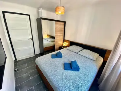 a bedroom with a bed with blue sheets and a mirror at Le Marignan By SCLS Locations in Cannes