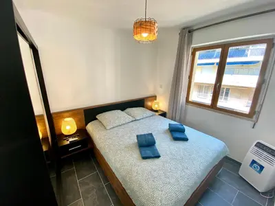 a bedroom with a bed with blue pillows on it at Le Marignan By SCLS Locations in Cannes