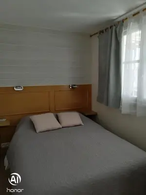 a bedroom with a bed with two pillows and a window at Macé9 in Cannes