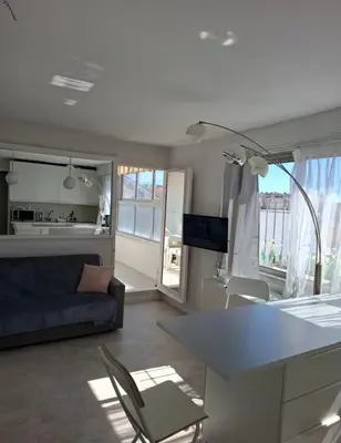 a kitchen and living room with a couch and a table at Macé9 in Cannes