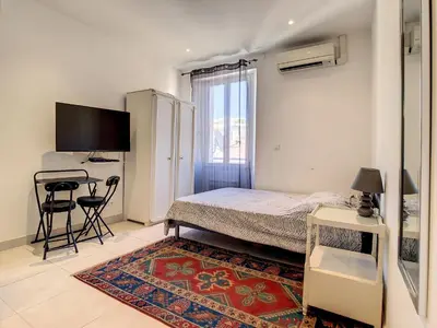 a bedroom with a bed and a desk and a television at Studio Carré d'Or. 2 mins from the Croisette. 143 in Cannes