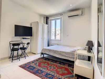 a bedroom with a bed and a desk and a television at Studio Carré d'Or. 2 mins from the Croisette. 143 in Cannes
