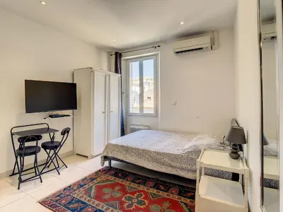a bedroom with a bed and a desk and a television at Studio Carré d'Or. 2 mins from the Croisette. 143 in Cannes