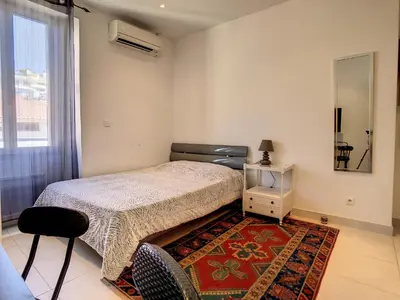 a bedroom with a bed and a rug and a window at Studio Carré d'Or. 2 mins from the Croisette. 143 in Cannes