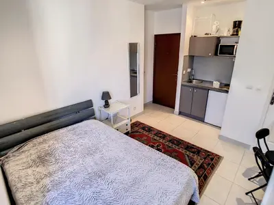 a small bedroom with a bed and a kitchen at Studio Carré d'Or. 2 mins from the Croisette. 143 in Cannes