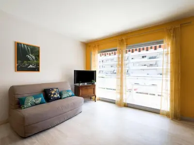 a living room with a couch and a large window at Apartment Le Morélia by Interhome in Cannes
