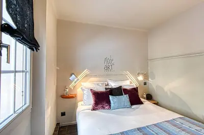 a bedroom with a bed with white sheets and purple pillows at C074-Cannes Studio - Cannes Forville in Cannes