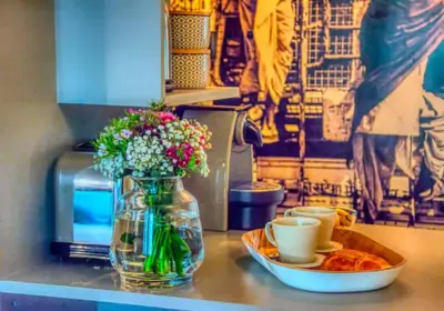 a table with a vase of flowers and a plate of food at C074-Cannes Studio - Cannes Forville in Cannes