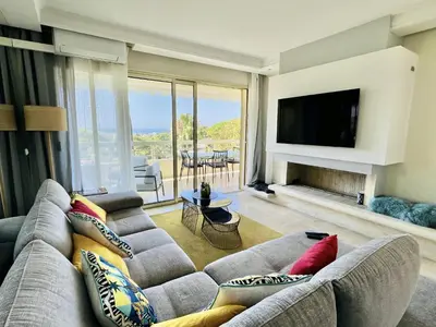 a living room with a couch and a television at Bella vista luxe 2 chambres in Cannes