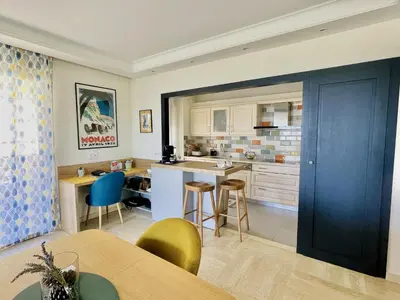a kitchen with a blue door and a table and chairs at Bella vista luxe 2 chambres in Cannes