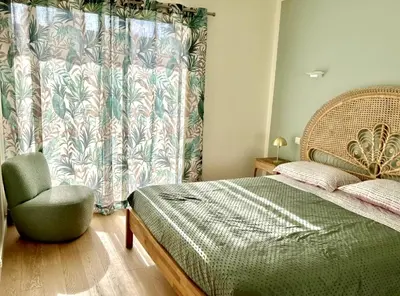 a bedroom with a bed and a chair and a window at Bella vista luxe 2 chambres in Cannes