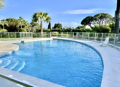 a swimming pool with a chair in the middle at Bella vista luxe 2 chambres in Cannes