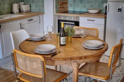a kitchen with a wooden table with glasses of wine at Le Joy - Terrasse - Parking - Verrière Côte d'Azur in Cannes