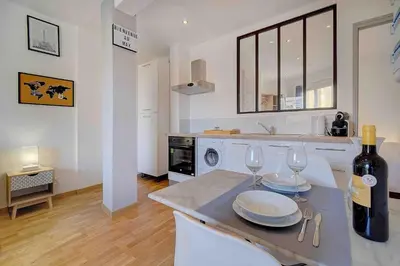 a kitchen with a table with a bottle of wine at Le Max et Leo - 600m plage - Verrière côte d'Azur in Cannes