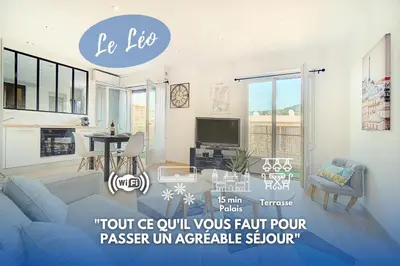 a living room with a blue couch and a tv at Le Max et Leo - 600m plage - Verrière côte d'Azur in Cannes