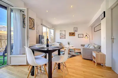 a dining room and living room with a table and chairs at Le Max et Leo - 600m plage - Verrière côte d'Azur in Cannes