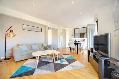 a living room with a couch and a tv at Le Max et Leo - 600m plage - Verrière côte d'Azur in Cannes