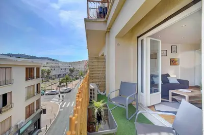 a balcony with a couch and chairs on a building at Le Max et Leo - 600m plage - Verrière côte d'Azur in Cannes