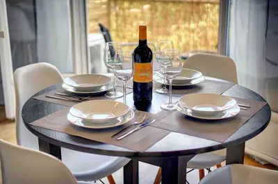 a table with a bottle of wine and plates and glasses at Le Max et Leo - 600m plage - Verrière côte d'Azur in Cannes