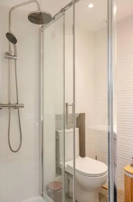 a bathroom with a toilet and a glass shower at Studio Blvd Carnot 10 min Palais Festivals - Balcony & AC in Cannes