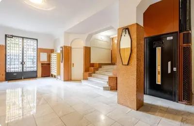 a lobby with stairs and a mirror on the wall at Studio Blvd Carnot 10 min Palais Festivals - Balcony & AC in Cannes
