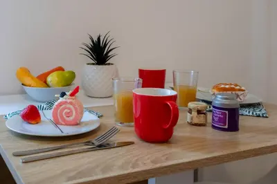 a table with plates of food and glasses of orange juice at Studio Blvd Carnot 10 min Palais Festivals - Balcony & AC in Cannes