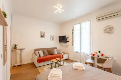 a living room with a couch and a table at Studio Blvd Carnot 10 min Palais Festivals - Balcony & AC in Cannes