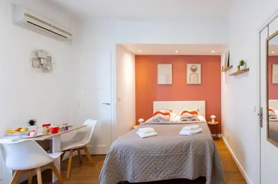 a bedroom with a bed and a table and chairs at Studio Blvd Carnot 10 min Palais Festivals - Balcony & AC in Cannes