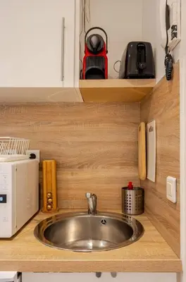 a kitchen counter with a sink and a microwave at Studio Blvd Carnot 10 min Palais Festivals - Balcony & AC in Cannes
