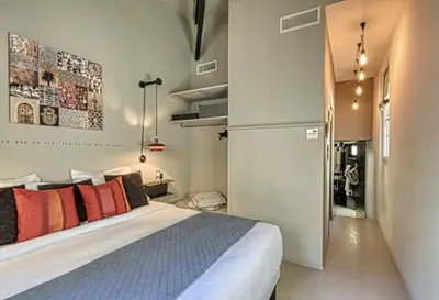a bedroom with a bed with orange pillows and a refrigerator at C075-Old Town Cannes - Duplex Apartment in Cannes