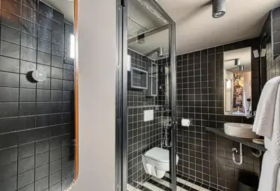 a bathroom with black tiled walls and a shower at C075-Old Town Cannes - Duplex Apartment in Cannes