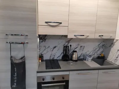 a kitchen with white cabinets and a stove top oven at Coquet 2 pièces entièrement rénové et climatisé in Cannes