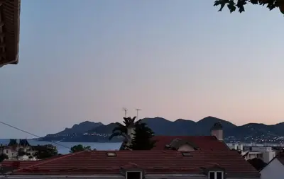 a view of the water and mountains from a city at Coquet 2 pièces entièrement rénové et climatisé in Cannes