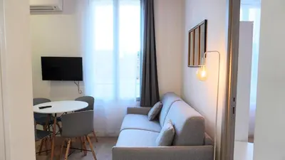 a living room with a couch and a table at Proche Carlton & Croisette, Appartement 101 - Palmazur Vacances in Cannes